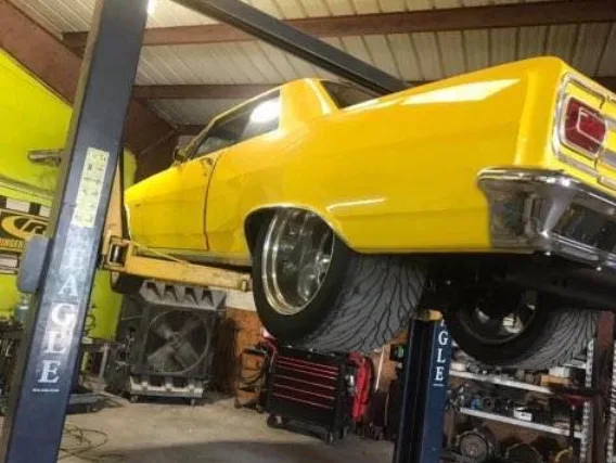 Yellow Chevelle up on a lift at Area 51 Auto